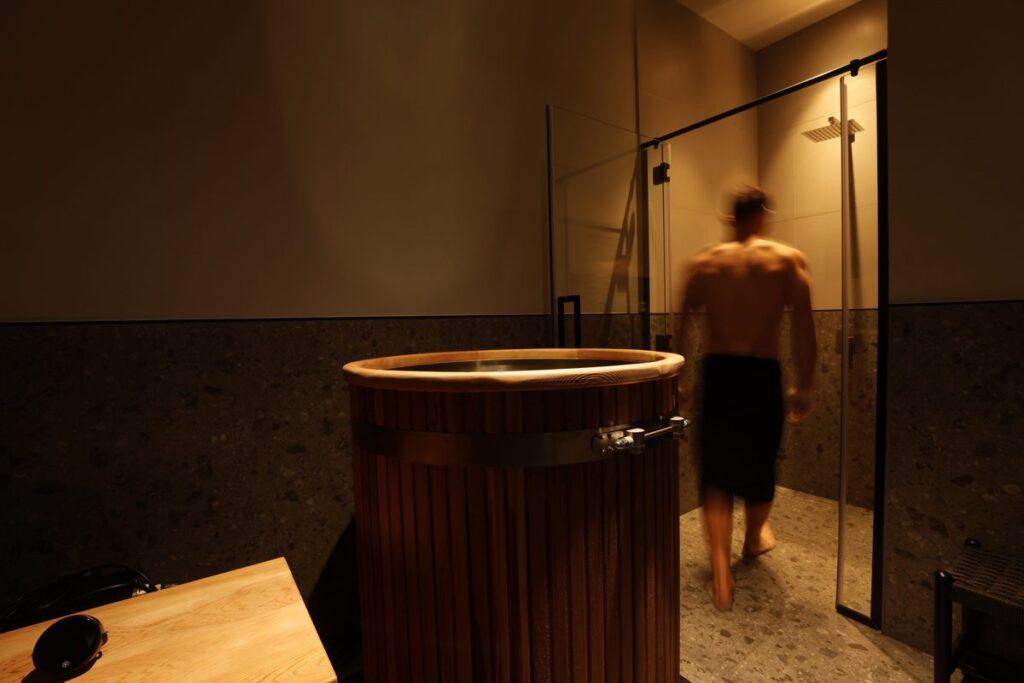 Cedar barrel ice bath and private shower in a cold plunge suite at Beit Sisu, Dubai Media City